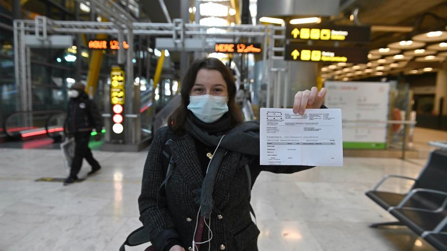 Una joven muestra el resultado de su PCR a su llegada al aeropuerto Adolfo Suárez-Barajas en Madrid, este lunes, donde comienza la exigencia de pruebas PCR para pasajeros de vuelos procedentes de países de riesgo.. EFE/ Fernando Villar