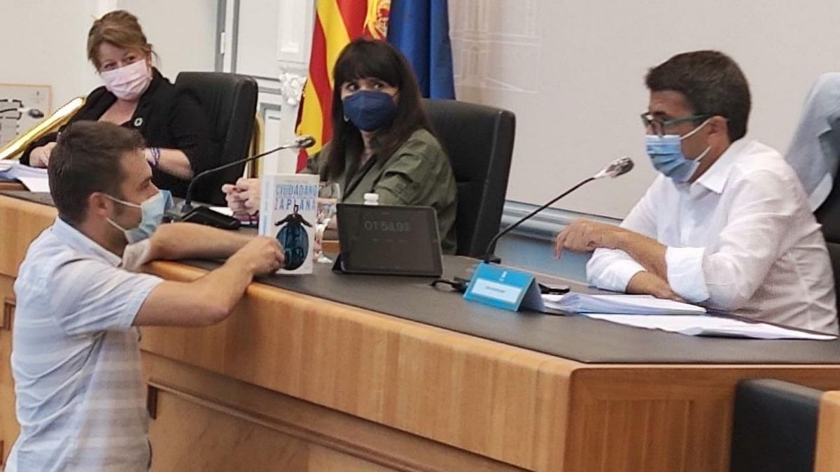 El portavoz de Compromís, Gerard Fullana, entrega la biografía de Zaplana al presidente de la Diputación de Alicante, Carlos Mazón.