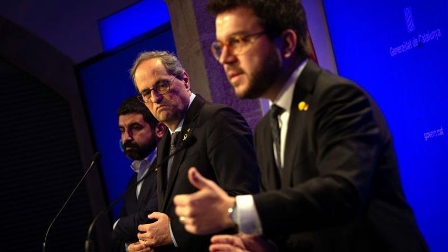 El presidente de la Generalitat, Quim Torra (c), junto con su vicepresidente, Pere Aragonès (d), y el conseller de Trabajo, Chakir El Homrani (i), durante una rueda de prensa.