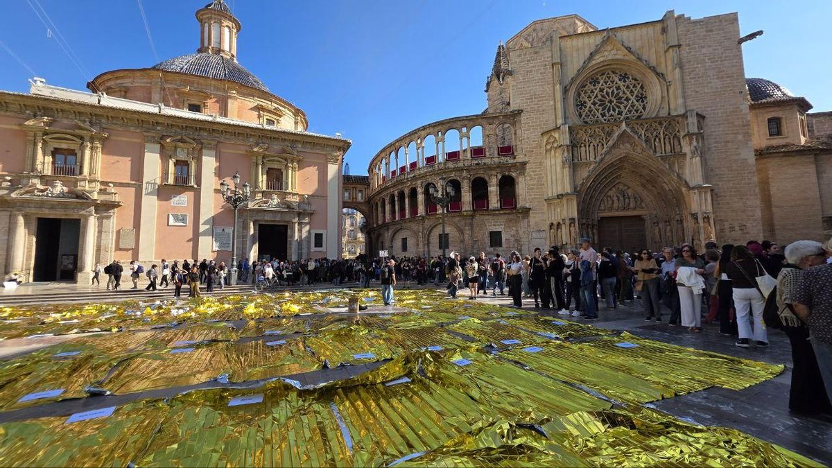 Las 229 mantas térmicas desplegadas en la plaza de la Virgen de València con los nombres de cada una de las víctimas.