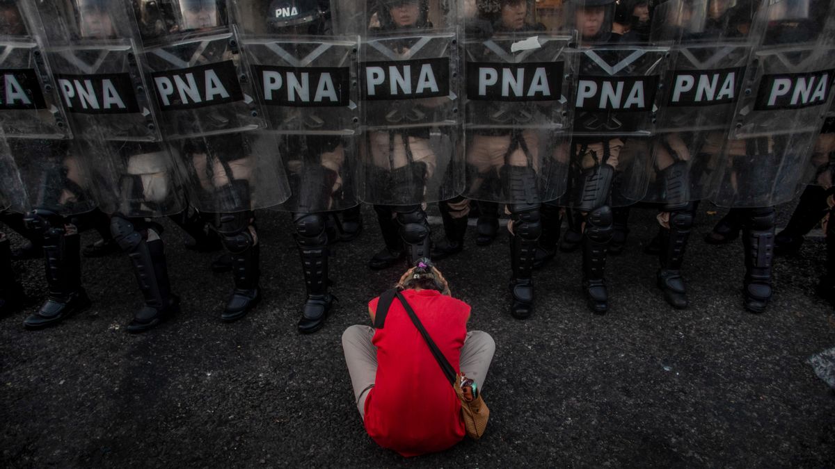 Una mujer intenta impedir la acción represiva de la Prefectura Nacional luego de que la Cámara de Diputados aprobara la Ley de Bases.