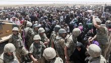 Refugiados sirios a la espera de cruzar desde su país la frontera que les separa de Turquía, cerca de Akçakale, en la provincia de Sanliurfa, Turquía. | Efe