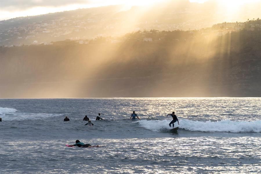 Varias personas practican surf en la playa de Martianez en el Puerto de la Cruz. (Efe / Miguel Barreto)