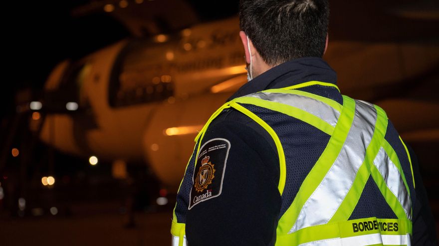 Fotografía cedida por las Fuerzas Armadas de Canadá donde aparece un agente del Servicio de Fronteras de Canadá supervisando la descarga del primer envío de la vacuna de Pfizer contra la covid-19, en el aeropuerto de Montreal (Canadá). EFE/Matthew Tower/Fuerzas Armadas de Canadá