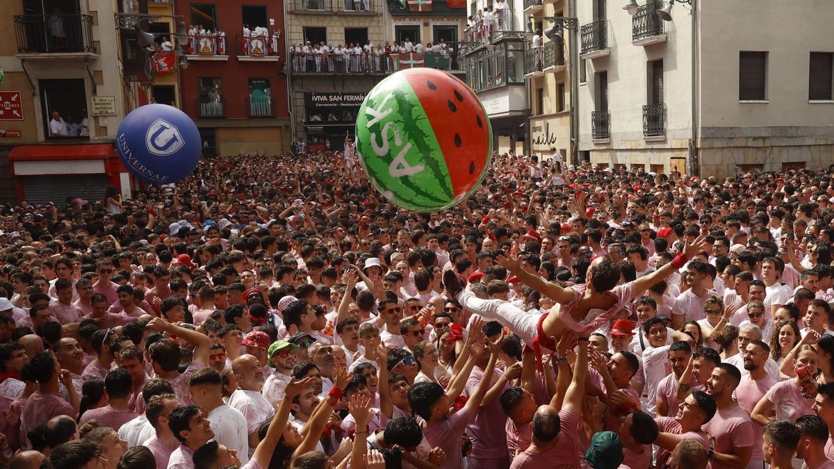 Una multitud celebra con vino el inminente comienzo de los Sanfermines, momentos antes del Chupinazo desde el balcón del ayuntamiento de Pamplona, este domingo. EFE/ Villar López