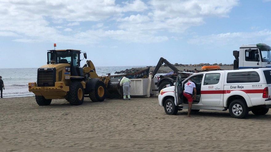 Un camión retira la patera llega a la Playa de Las Burras a primera hora de este domingo.