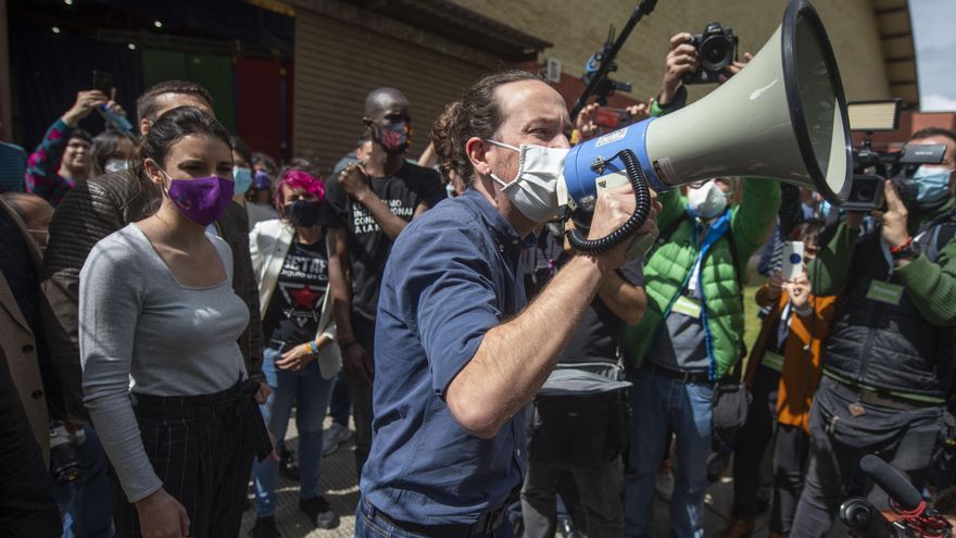La ministra de Igualdad y el candidato de Unidas Podemos a la Presidencia de la Comunidad, Pablo Iglesias con un megáfono se dirige al público durante un acto del partido en el Polideportivo municipal Cerro Buenavista de Getafe, a 27 de abril de 2021, en