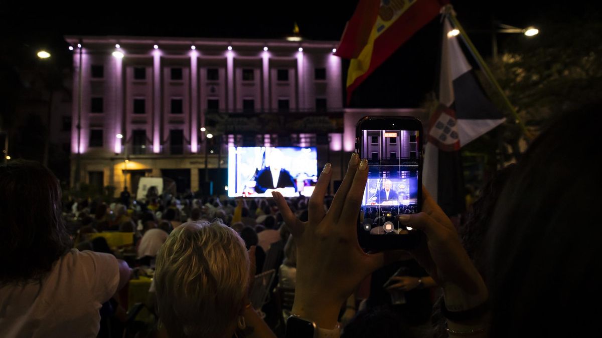 Un vecino graba con el telefono la pantalla que se ha instaldo en la Plaza de los Reyes para la entrevista de Juan Vivas en el hormiguero. Ceuta, 14 de septiembre de 2026