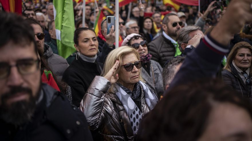 Una mujer hace el saludo militar mientras suena el himno de España.