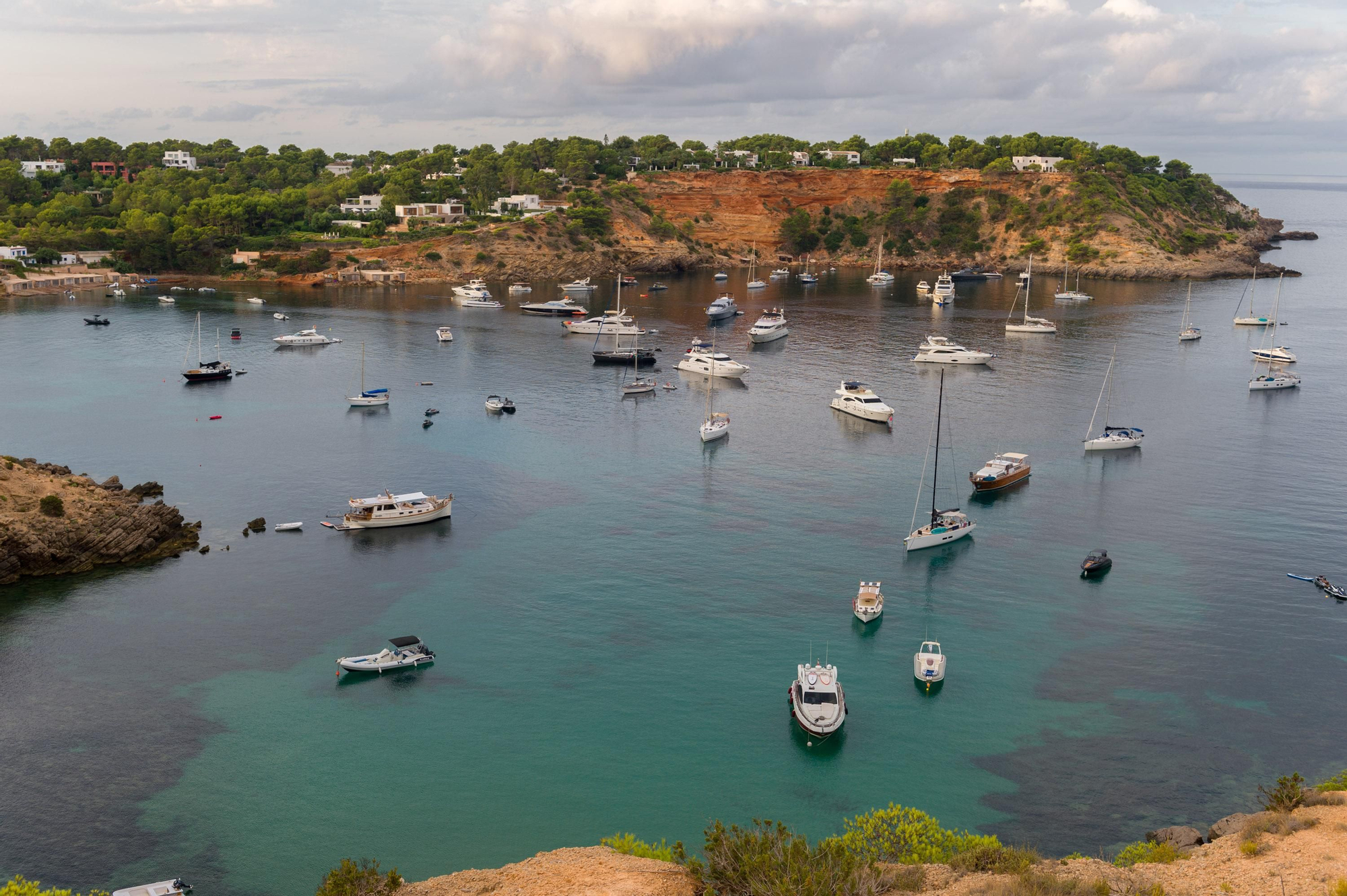 Barcos fondeados en la cala de Porroig, una zona de gran valor ecológico gracias a los fondos marinos, formados por praderas de posidonia