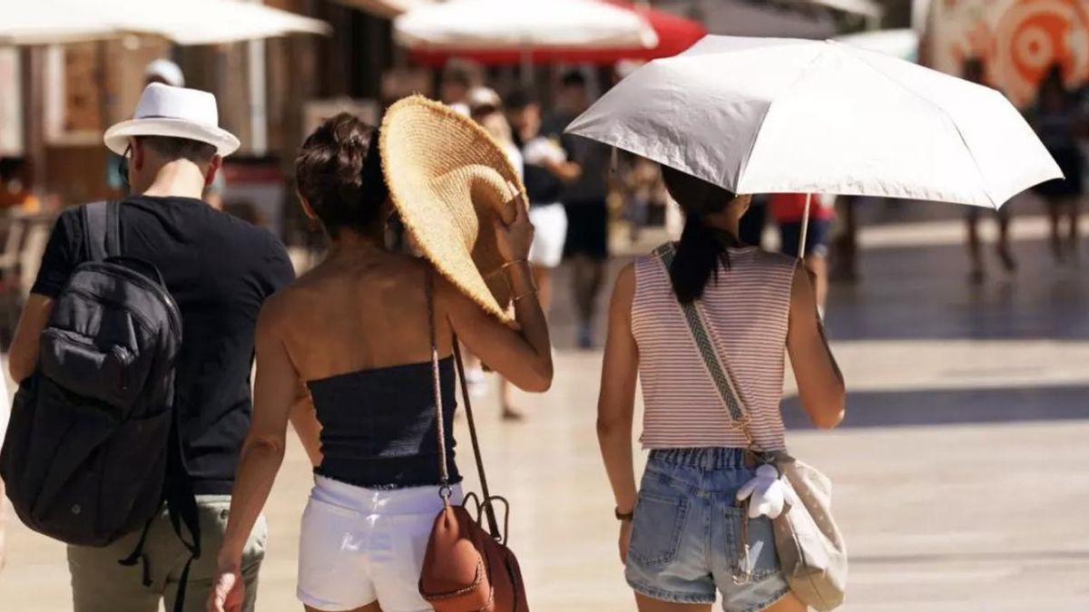 Imagen de archivo de tres personas caminando durante una ola de calor