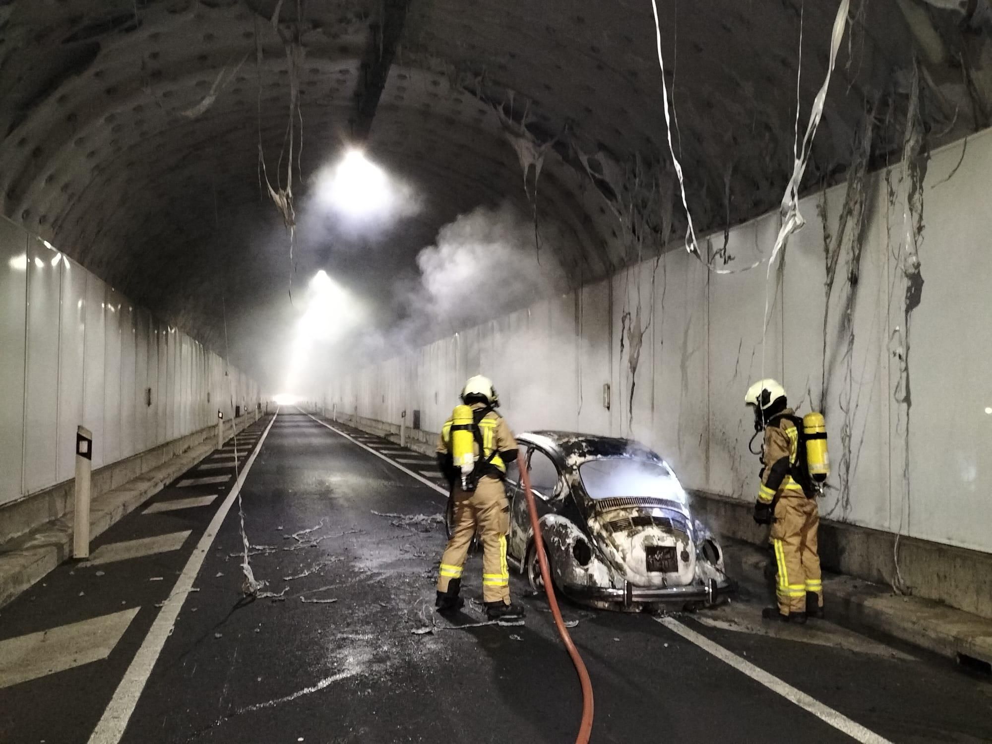 Dos Bomberos, en la tarde de este jueves, sofocando el incendio de un vehículo en el interior del Túnel Viejo.