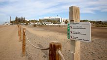 Charca de Maspalomas con el Faro y varios hoteles al fondo.