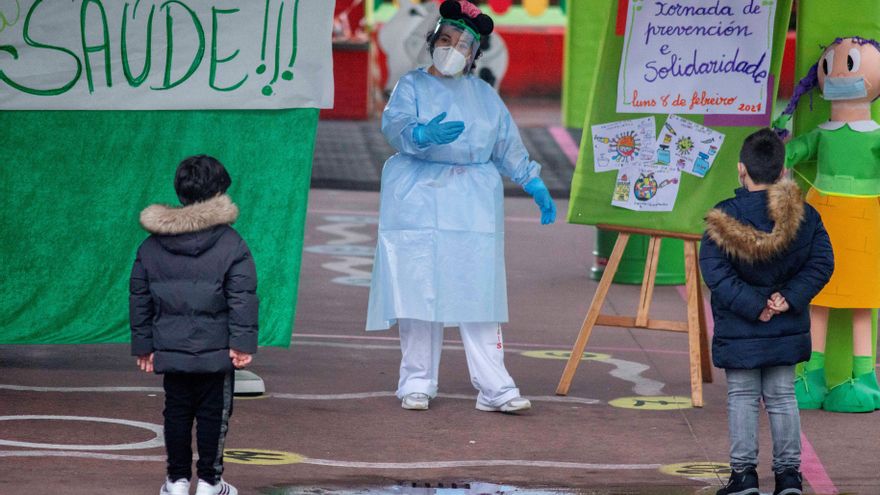 Galicia marca un nuevo récord en UCI pese al descenso de casos y de contagios. En la imagen, una sanitaria junto a unos niños durante un cribado masivo realizado hoy lunes en el centro educativo CEIP A Ponte. EFE/Brais Lorenzo