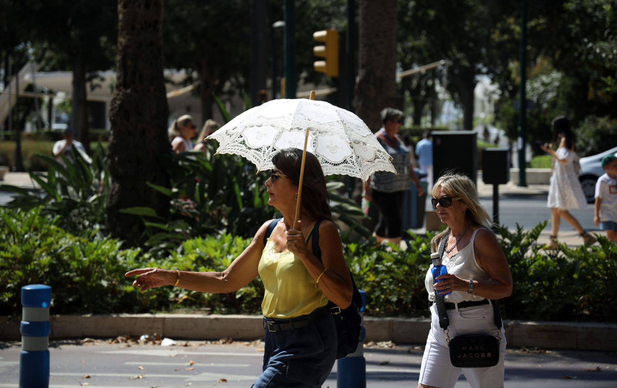 Dos mujeres se protegen de las altas temperaturas en Málaga durante la segunda ola de calor del verano
