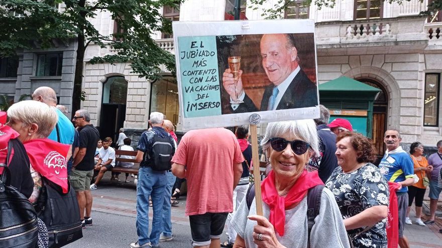 Una manifestante porta un cartel sobre el Rey emérito.