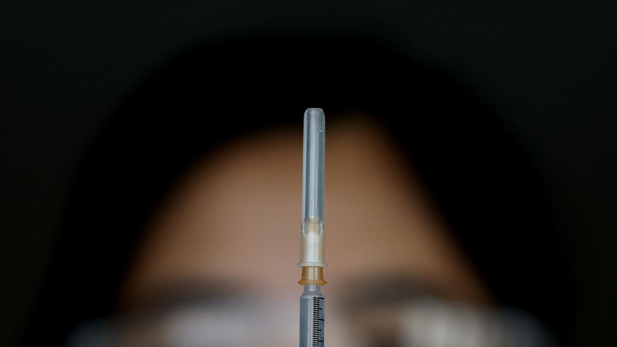 A nurse holds a needle containing Pfizer COVID-19 vaccine at Qudoa Bank Arena vaccination clinic in Sydney, Sunday, September 5, 2021. (AAP Image/Brendon Thorne) NO ARCHIVING