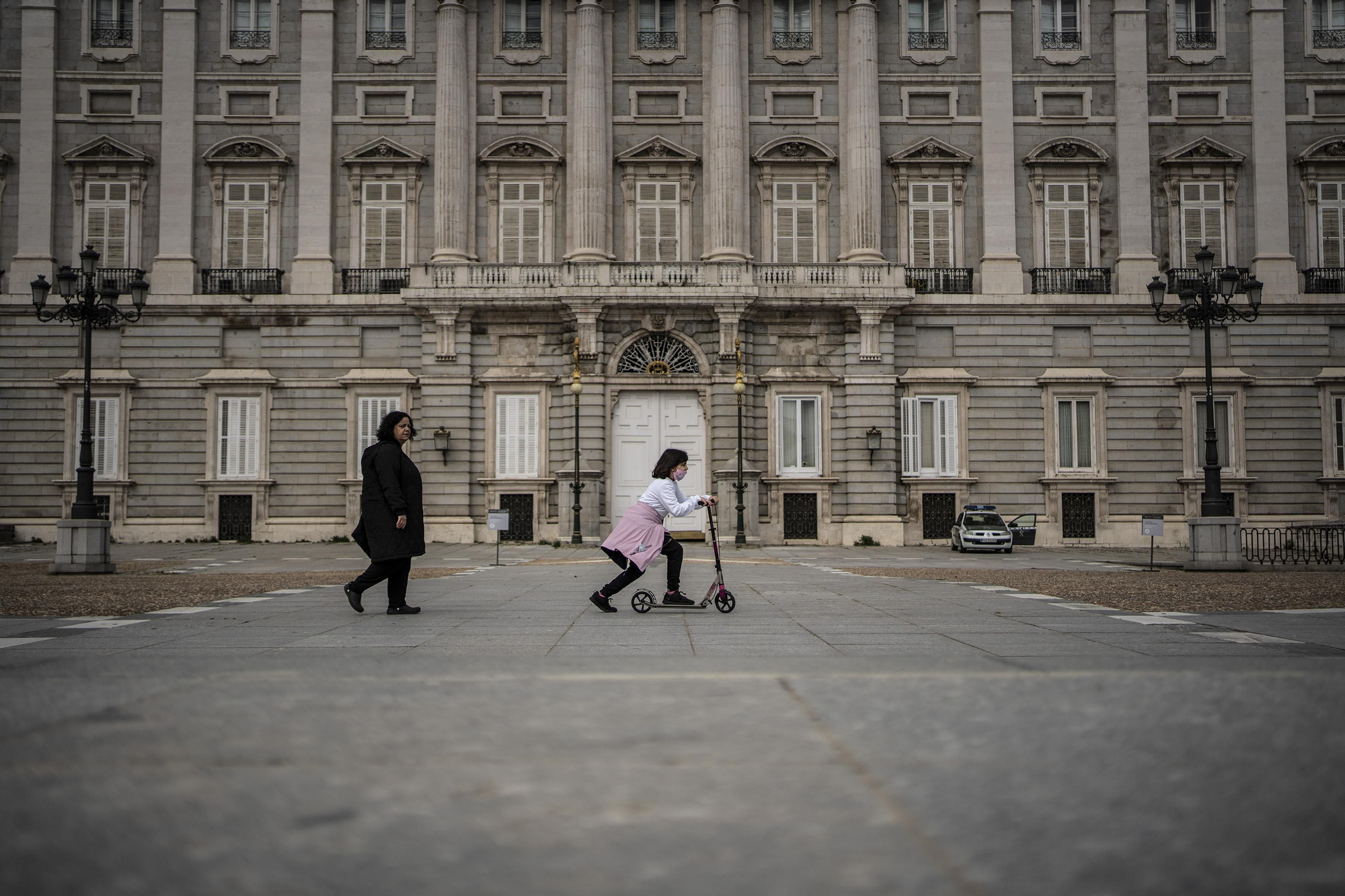 Madre e hija con patín en frente del Palacio Real