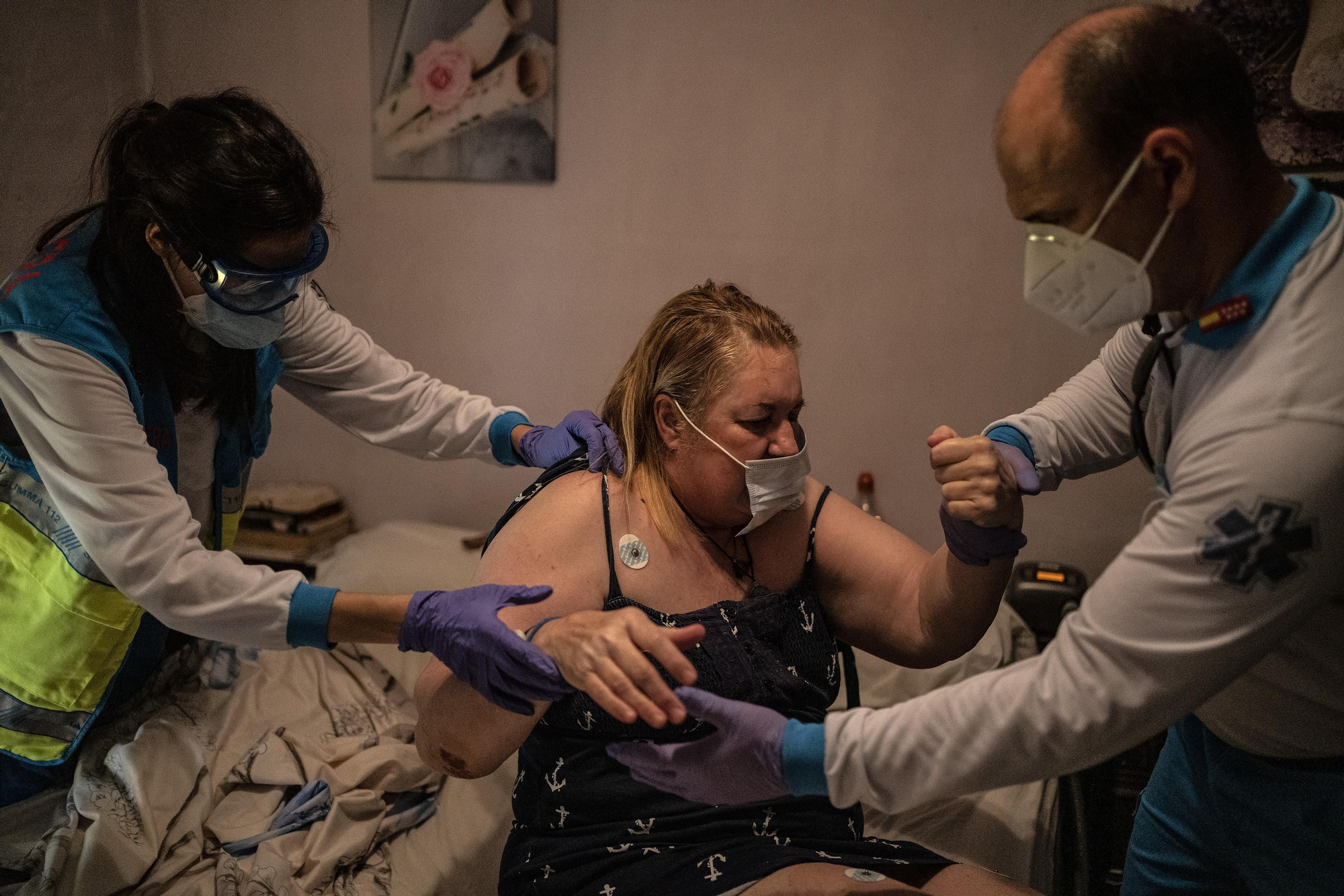 Ana Moreno, enfermera, e Ignacio Crespo, técnico en emergencias, ayudan a Mari Carmen a levantarse de su cama.