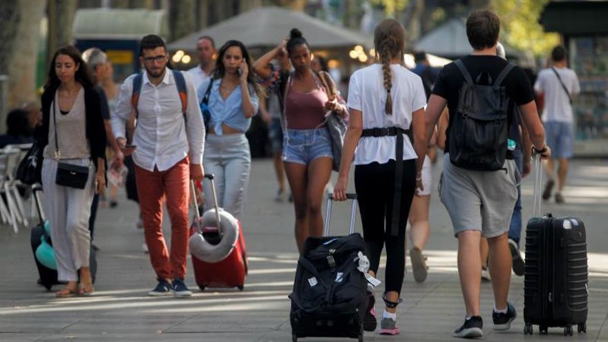 Turistas caminando por La Rambla de Barcelona.