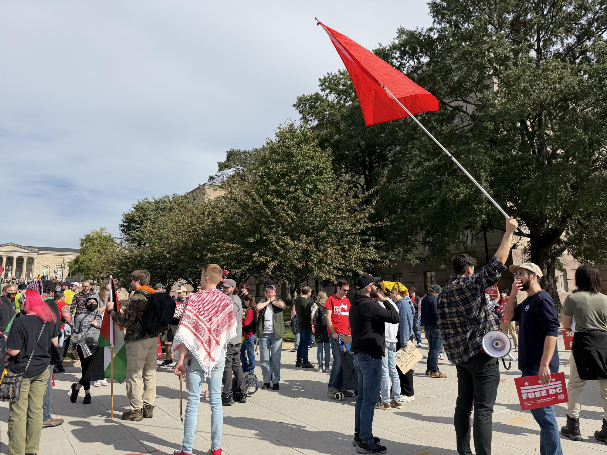 Zachary Tashman, con la bandera roja al inicio de la manifestación 'No Kings' en Washington DC, el 18 de octubre de 2025.