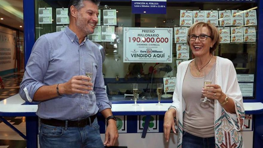 Esther Gloria Almeida, titular de la administración de loterías 54 de Las Palmas de Gran Canaria, sirve champán a sus clientes para celebrar el premio de 190 millones de euros del sorteo del Euromillón vendido en su administración. EFE/Elvira Urquijo A.