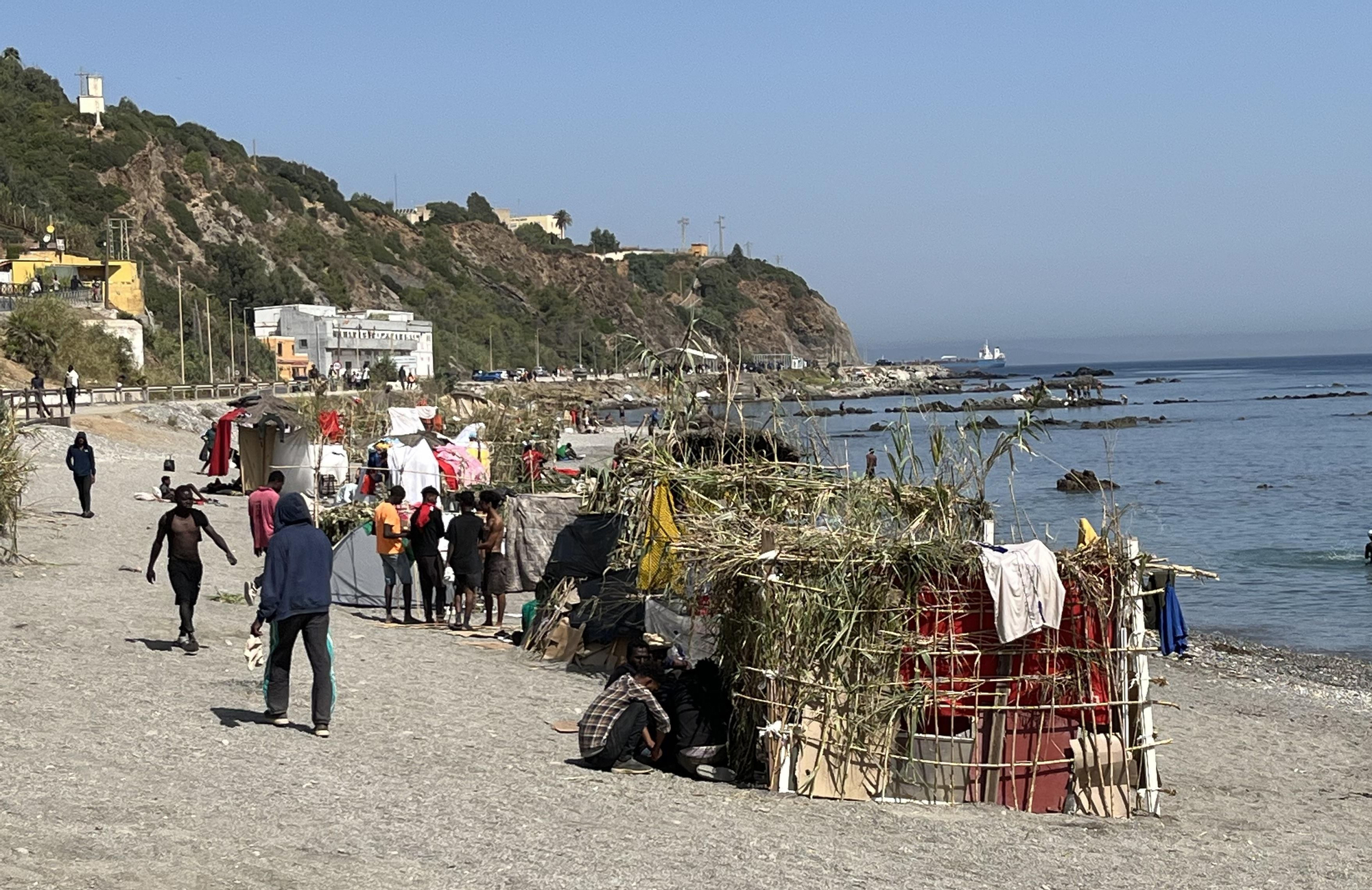 Numerosas personas permanecen en la playa del Trampolín de la ciudad española de Ceuta, fronteriza con Marruecos, que se ha transformado en un asentamiento desde la entrada masiva registrada el 30 de julio. EFE/Reduan