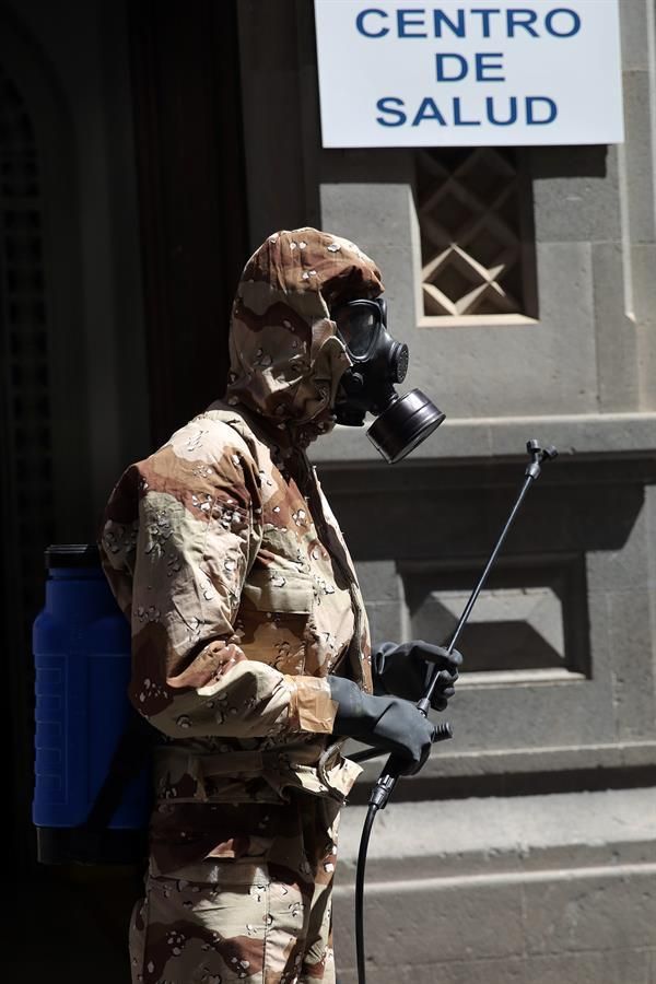 Efectivos del Ejército de Tierra, con trajes de protección, realizan labores de desinfección en el centro de salud de la zona centro de Santa Cruz