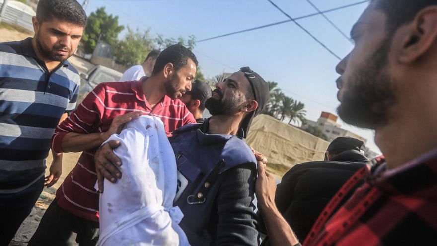 El periodista Mohamed Al-Aloul llevando el cuerpo de uno de sus hijos, asesinados en un campo de refugiados en Gaza