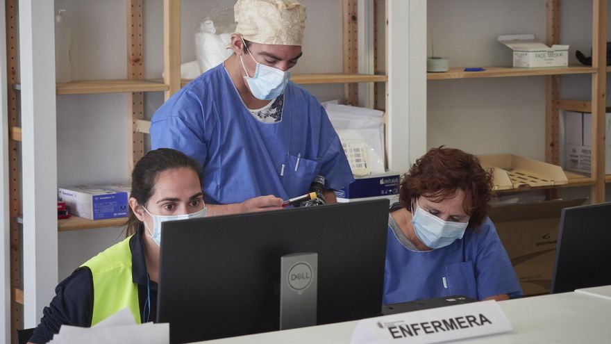 Trabajadores sanitarios protegidos atienden a los pacientes que acuden para realizarse una extracción de muestras en el recinto ferial REFENA de Pamplona.