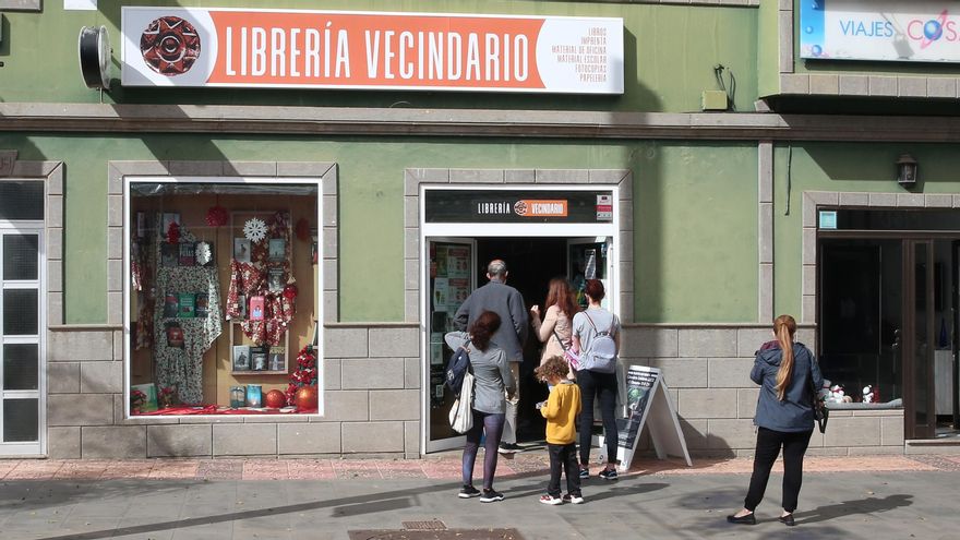 Personas haciendo fila para entrar en una librería de Vecindario
