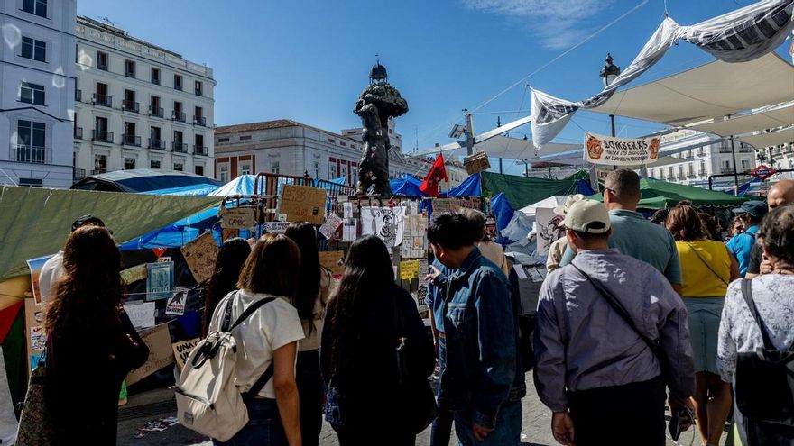 Varias personas observan los mensajes, en la Puerta del Sol, a 10 de octubre de 2026, en Madrid (España).