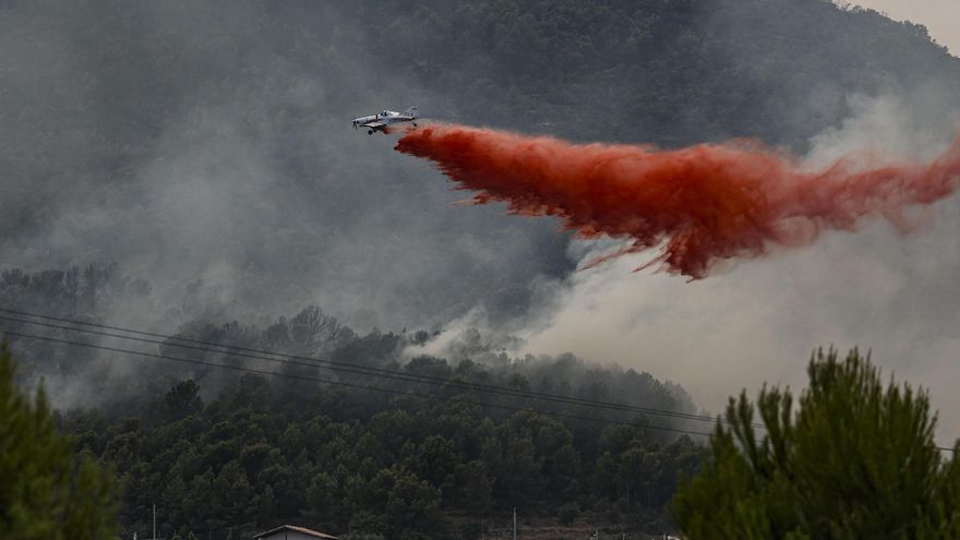 Un avión realiza una descarga con retardante en Betxí en el frente del incendio declarado este sábado en la Vall d'Uixó.