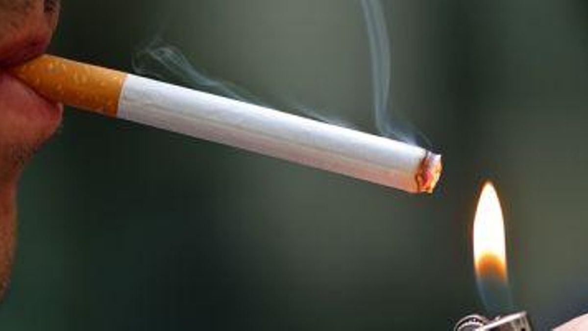 Una persona, fumando un cigarro.