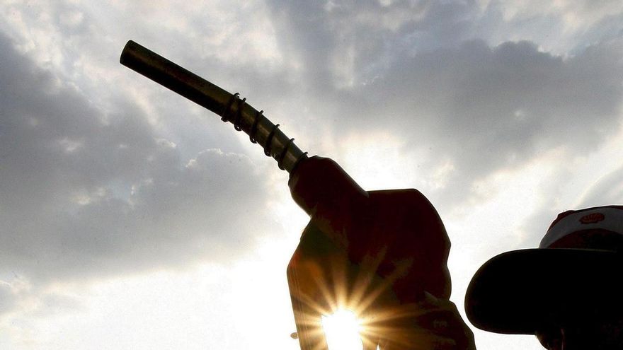 Imagen de un hombre con la manguera de un surtidor de una gasolinera.