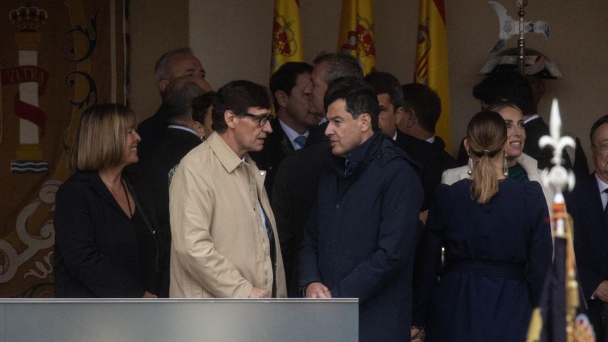El presidente de la Generalitat de Catalunya, Salvador Illa (c), y el presidente de la Junta de Andalucía, Juanma Moreno (d), durante el acto solemne de homenaje a la Bandera Nacional y desfile militar por el 12 de octubre en Madrid.