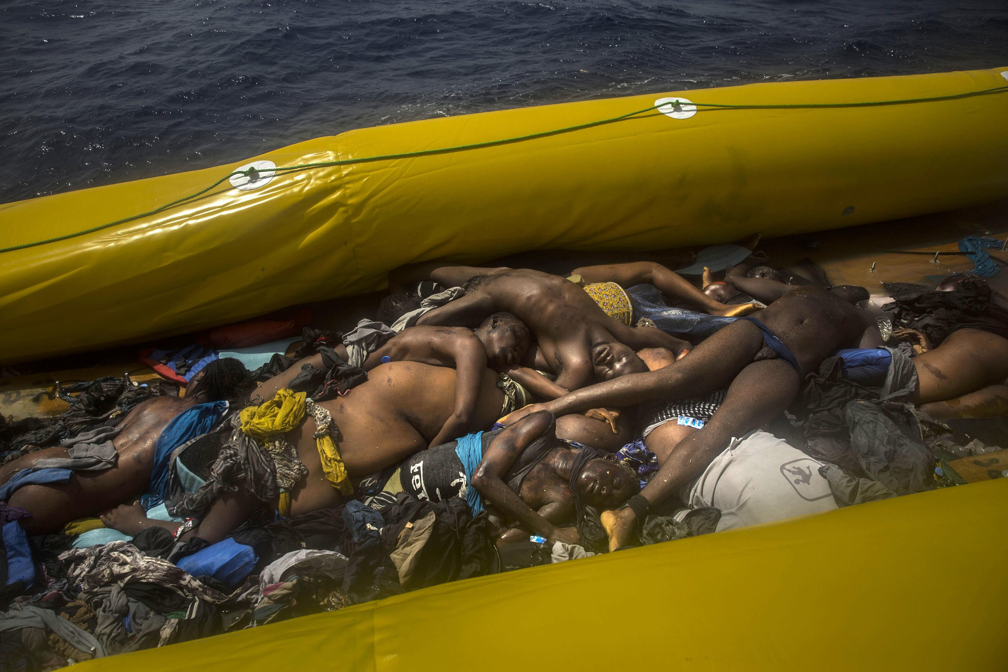 Los cuerpos sin vida de un grupo de migrantes yacen dentro de un bote de goma en el mar Mediterráneo, a unos 24 kilómetros al norte de Sabratha, Libia, el martes 25 de julio de 2017. Foto: AP Photo / Santi Palacios.
