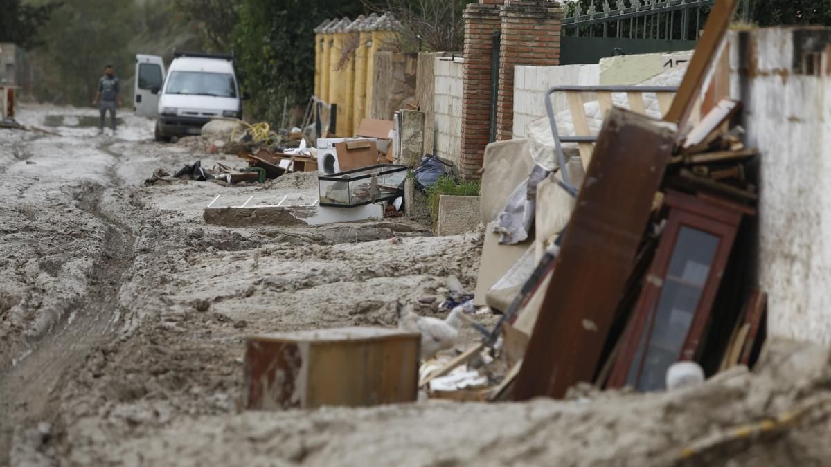 Vecinos de la calle La Perdiz, de la urbanización Guadalvalle, reclaman la retirada del barro y enseres