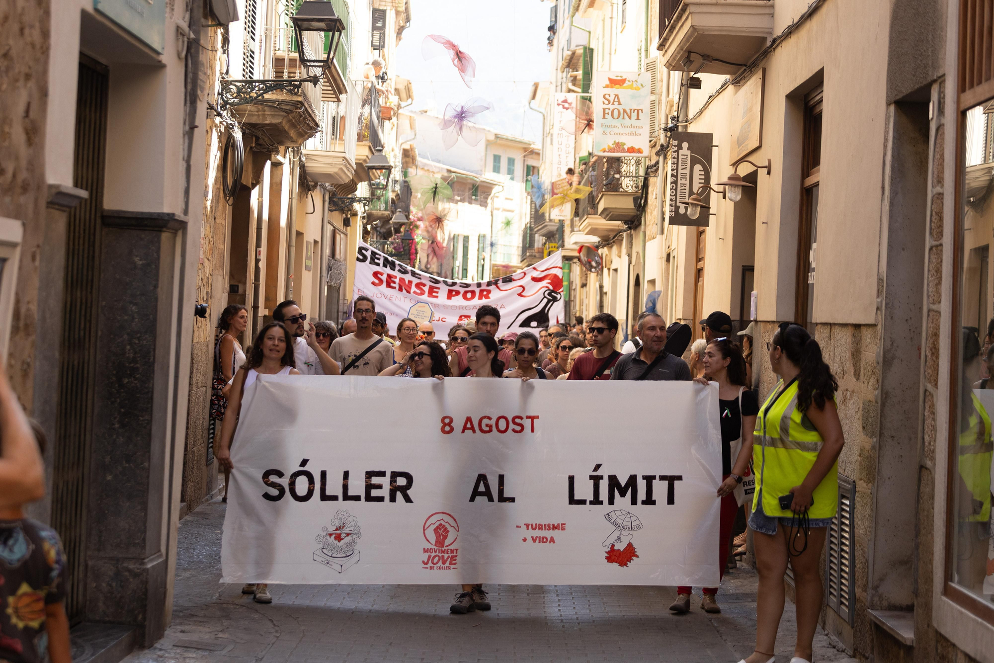 Manifestantes portan la pancarta principal de la protesta, con el lema "Sóller al límit"