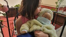 Eleonor con su muñeco bebé, protegido por mascarilla.