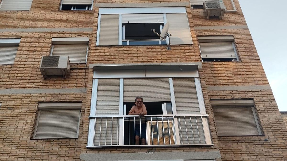 Un hombre tomando el fresco sin camiseta en plena ola de calor en el barrio de Carabanchel.