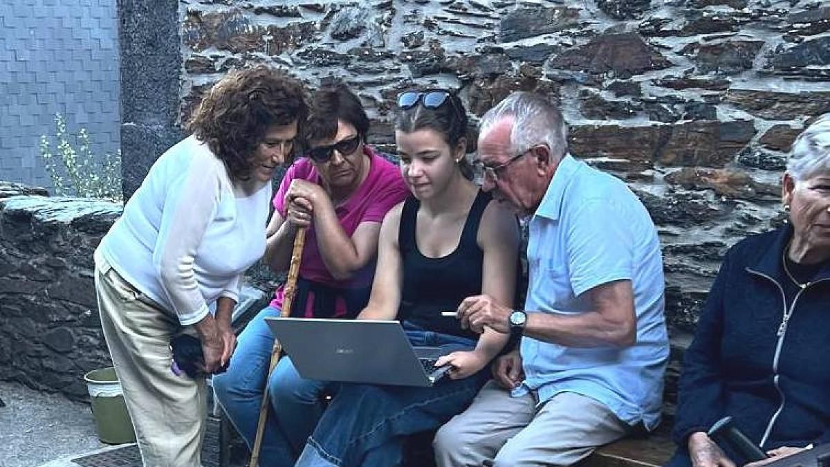 Diana Claro, con el portátil, entrevistando a los vecinos de Peranzanes por los topónimos de Fornela