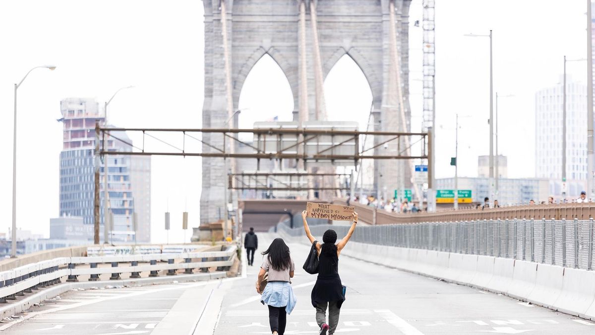 Two people walk along the closed roadway of the Brooklyn Bridge to join a protest against the COVID-19 vaccination mandates for municipal employees in New York, New York, USA, 25 October 2021.