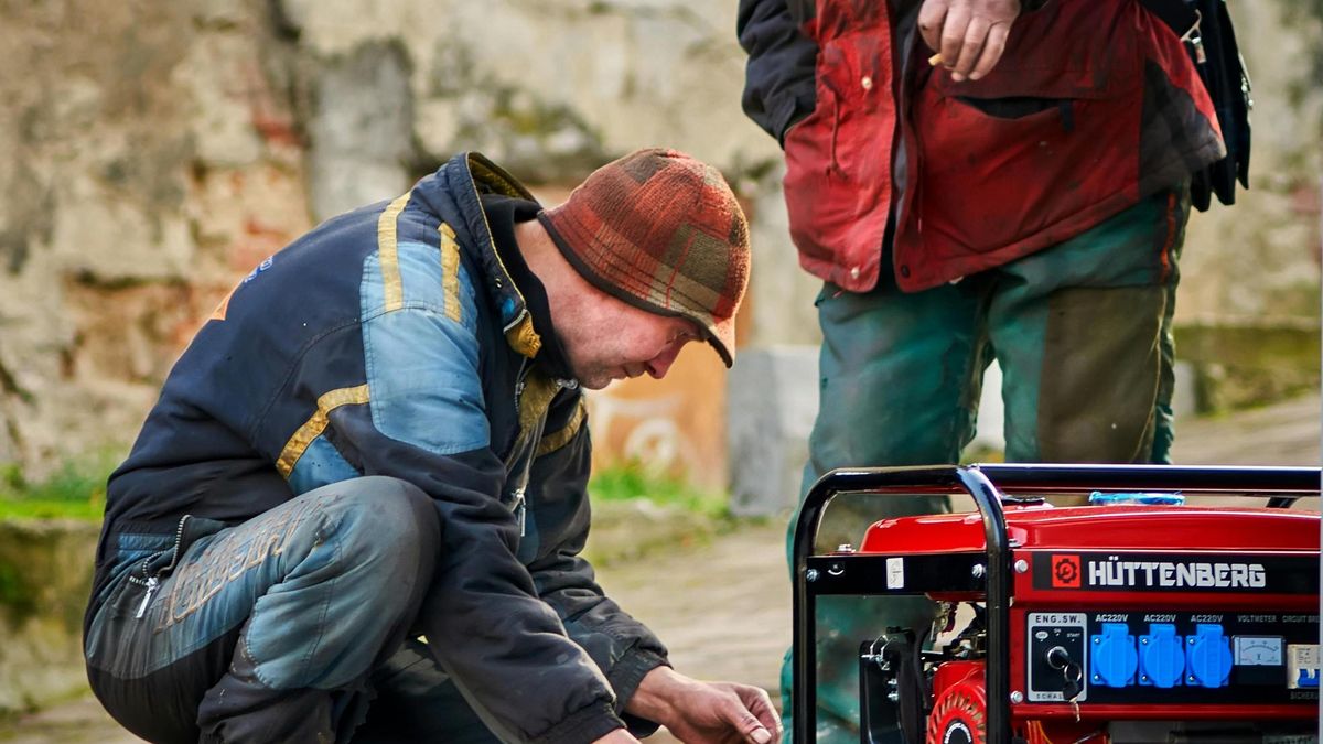 Imagen de archivo de técnicos manejando un generador.