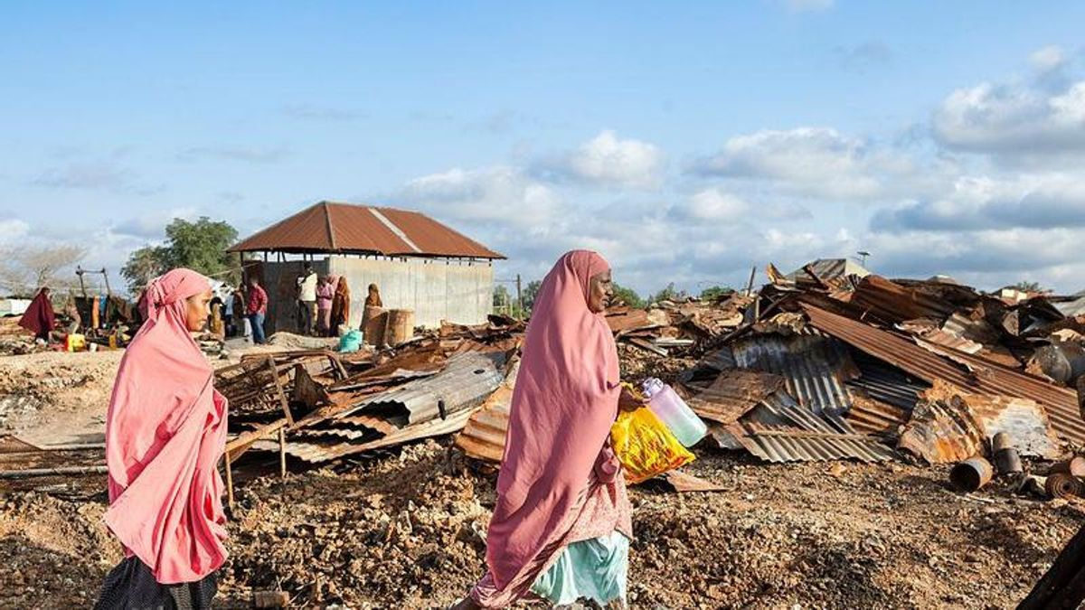 Los aldeanos caminan entre los escombros de su aldea, destruida por supuestos insurgentes en retirada, en Awdheegle, una de las varias ciudades recientemente liberadas de los militantes vinculados a Al-Qaeda, Al-Shabaab en la región de Bajo Shabelle de Somalia el 11 de noviembre de 2025.