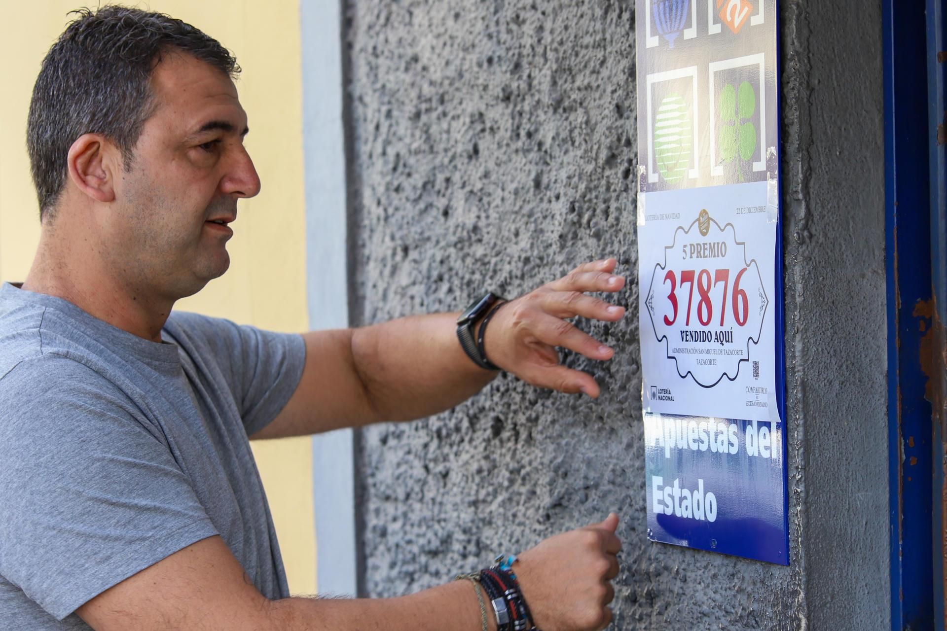 El gerente de la administración de loterías número 1 de Tazacorte (La Palma), Albert Acosta, celebra el reparto del 37.876, un quinto premio del sorteo extraordinario de Navidad de la Lotería Nacional, del que ha vendido 45 series. EFE/ Luis G. Morera