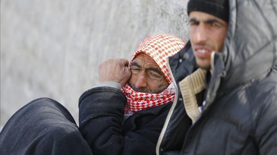 Refugiados sirios esperan sentados junto a la puerta fronteriza de Oncupinar en la ciudad de Kilis, Turquía, el 5 de febrero de 2016.