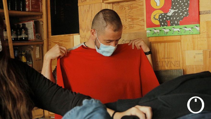 Un joven se prueba ropa en un mercadillo de trueque