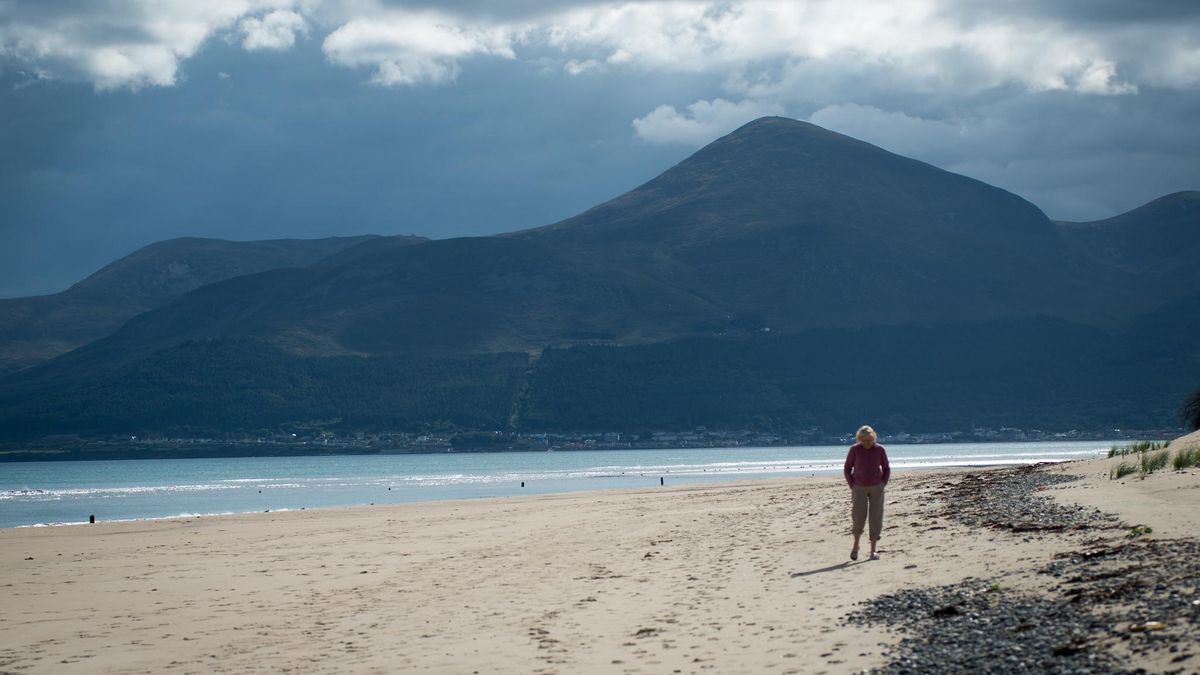 Arenas blancas en Murlough Beach. Al fondo puede verse la silueta del Slieve Donard, la cima más alta del Mourne.