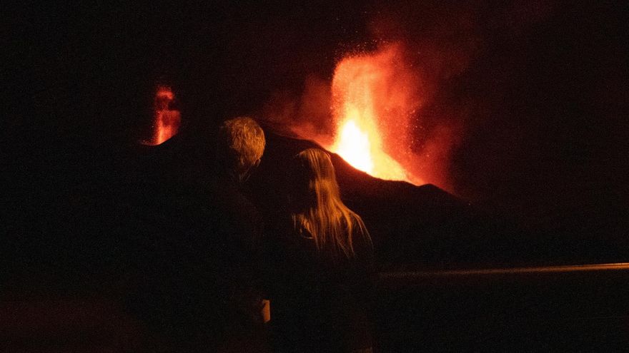 Dos personas observan el volcán de La Palma durante la noche de este martes 26 de octubre.